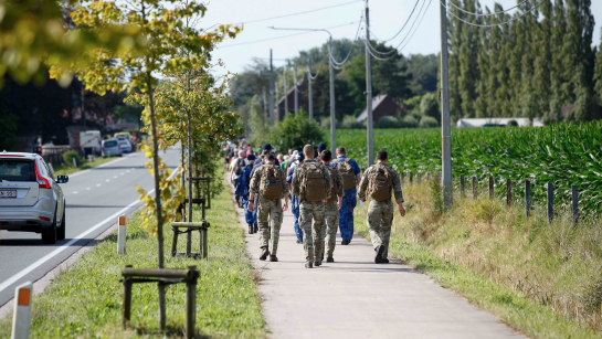 Deelnemers en militairen wandelen langs het parcours van de vierdaagse van de ijzer