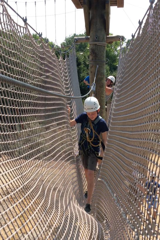 Deelnemer aan het hoogteparcours steekt over in een net