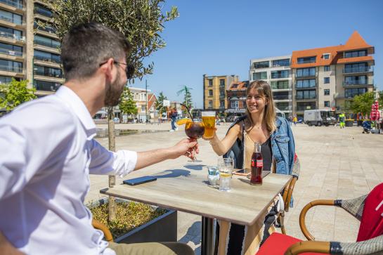 Een koppel geniet van een drankje op een terras