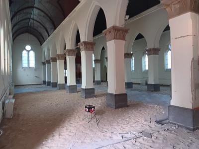 De tegelvloer van de linkervleugel van de kerk wordt uitgebroken